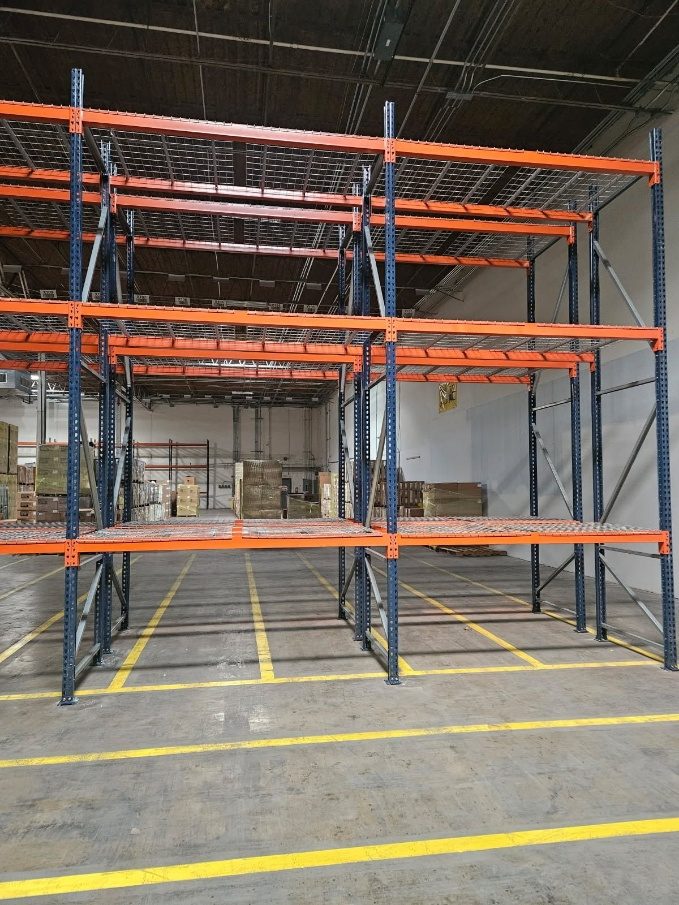 Black upright selective pallet rack with orange beams and wire decking
